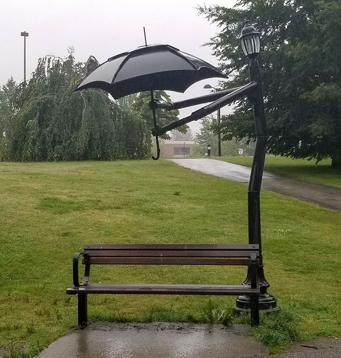 ce lampadaire retient un parapluie pour une place sur le banc