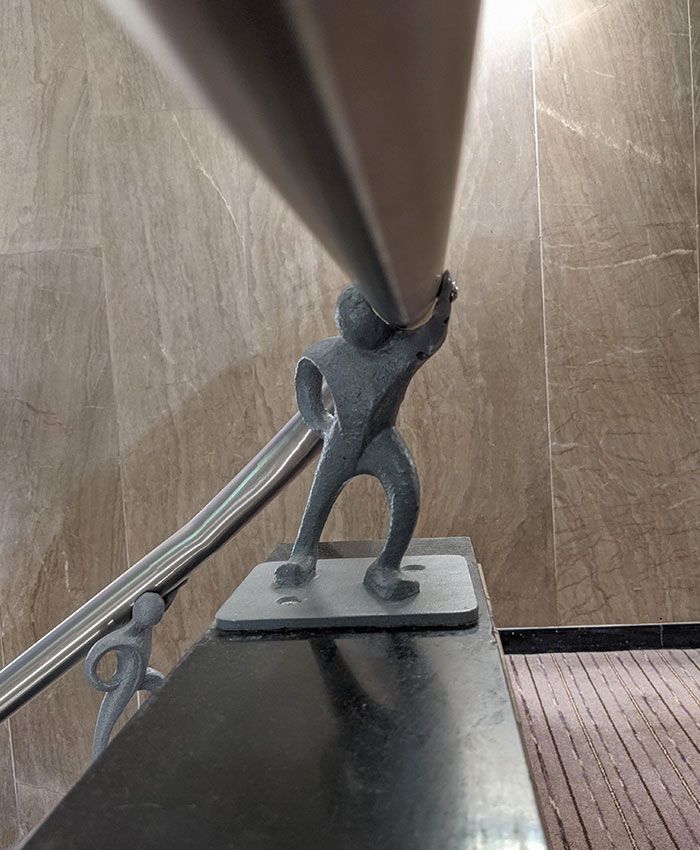 les rampes d’escalier de mon hôtel étaient maintenues par de petits hommes en métal