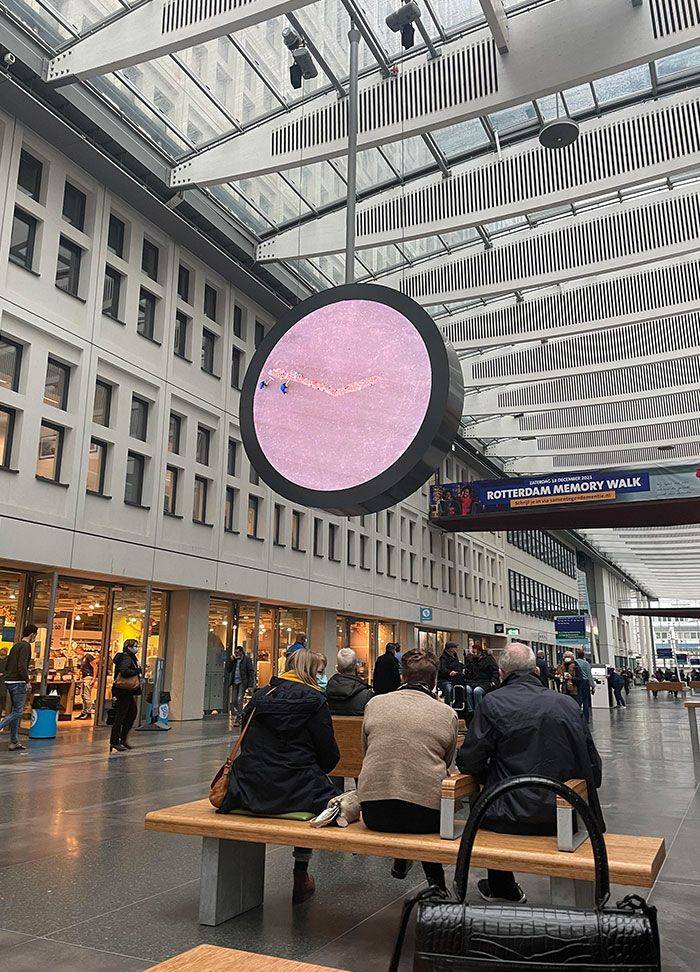 cette horloge à l’erasmus mc de rotterdam utilise une vidéo de personnes qui ramassent des ordures comme aiguilles d’horloge.