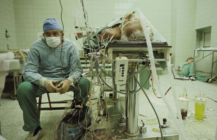 le dr. religa surveille les signes vitaux de son patient après une transplantation cardiaque (réussie) de 23 heures. son assistant dort dans un coin, 1987.