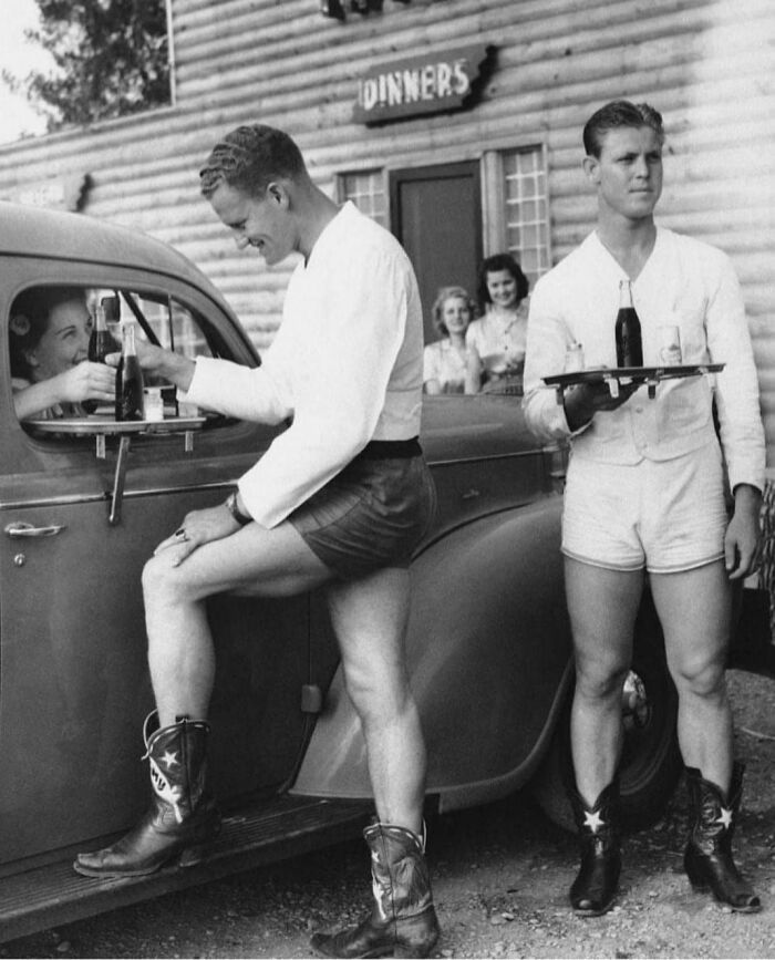 dans les années 1940, des hommes vêtus de shorts et de bottes de cowboy ont servi des femmes dans un drive-in à dallas, au texas “log lodge tavern”.