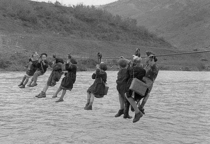 Des enfants allant à l’école doivent traverser une rivière en poulie, Modène, Italie, 1959.