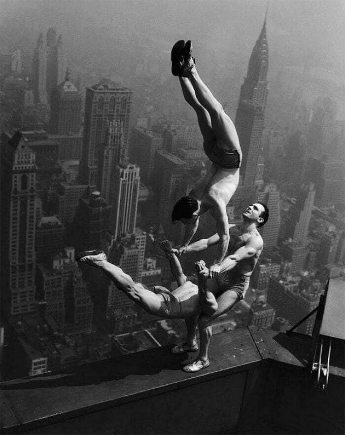 des acrobates en équilibre au sommet de l’empire state building, c. 1934