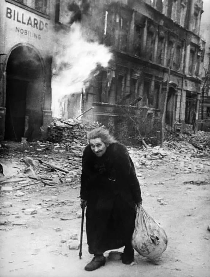 une femme marche dans les ruines de berlin pendant la bataille de berlin, mai 1945