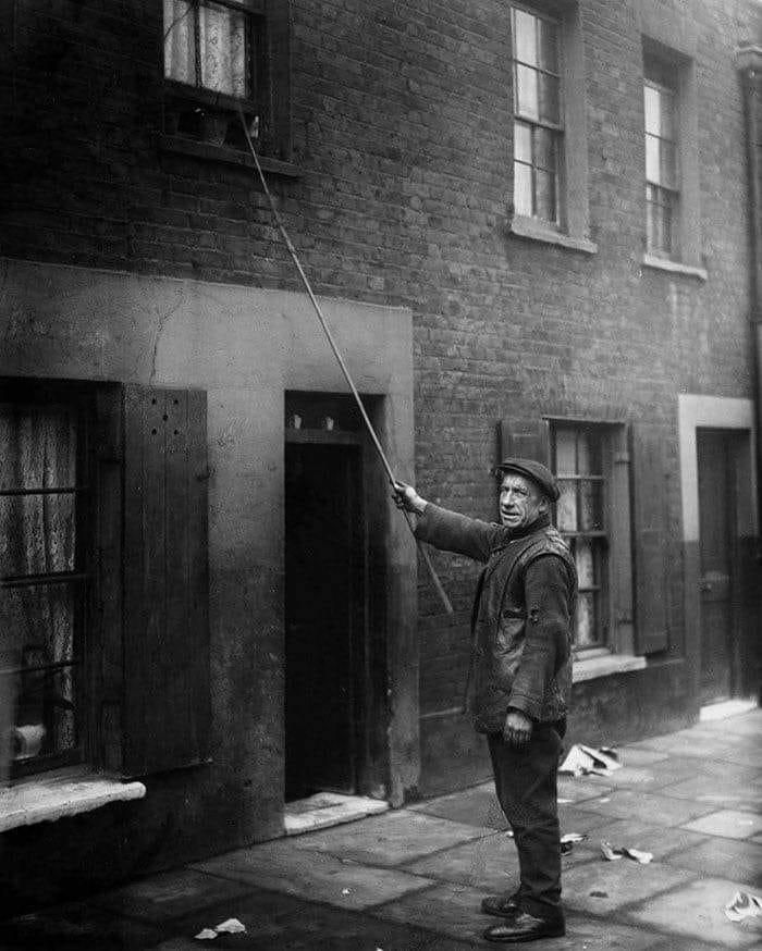 un “knocker-up” à londres (1929). avant les réveils, les gens étaient payés pour réveiller les clients pour le travail en frappant à leurs portes et fenêtres avec un bâton.