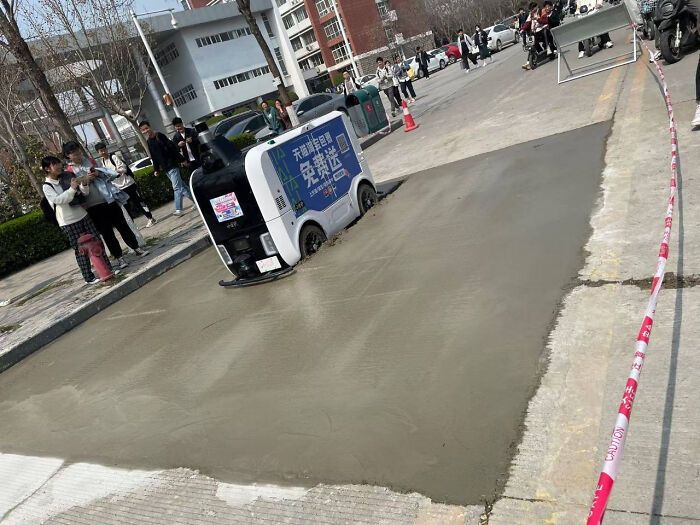 Un robot de livraison essaie de marcher sur du ciment non séché