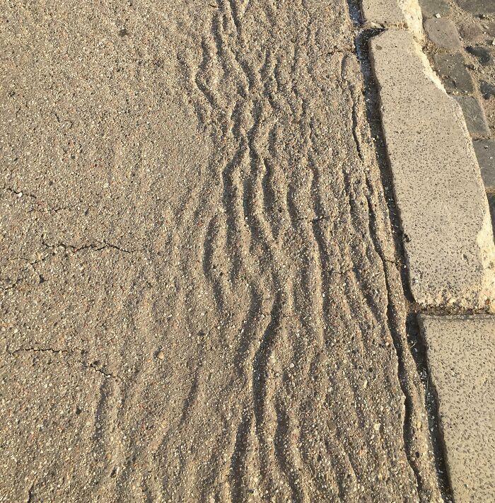 La chaleur a provoqué des vagues sur le trottoir en asphalte.