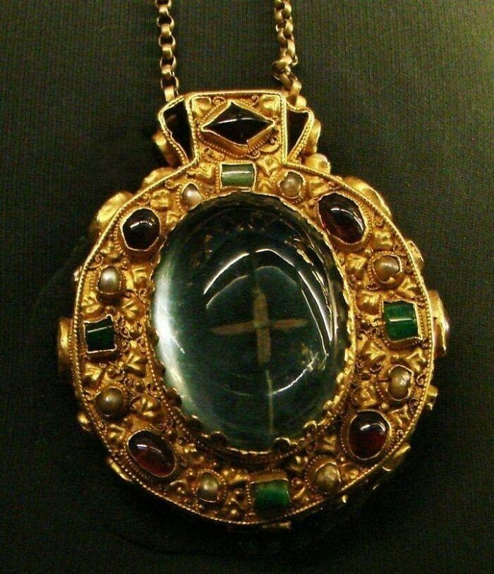 le talisman de charlemagne, vers 768-814. deux grands saphirs cabochons – un ovale, un carré – renferment des reliques sacrées (ce qui est censé être un reste de la sainte croix et un petit morceau des cheveux de la vierge, visible uniquement en regardant à travers le saphir ovale à l’avant du médaillon). les autres pierres précieuses sont des grenats, des émeraudes et des perles.