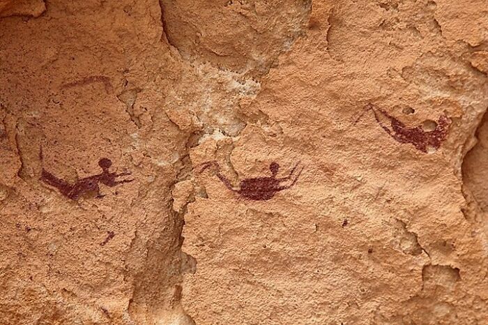 pictogrammes néolithiques représentant des personnes aux membres pliés comme si elles nageaient. date : il y a 10 000 ans. grotte des nageurs, plateau de gilf kebir, égypte