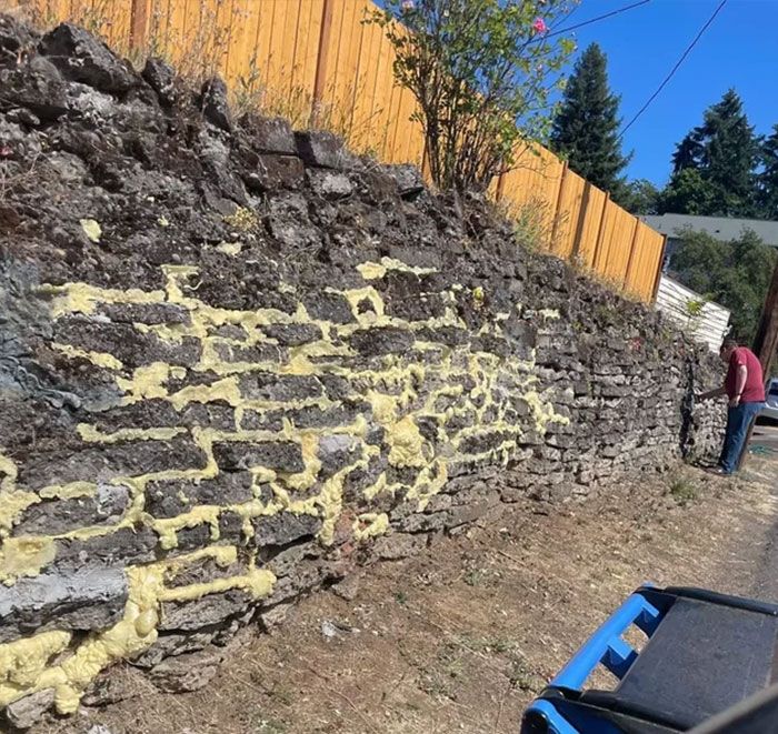 Les voisins tentent de renforcer leur mur de pierre avec….spray foam insulation.