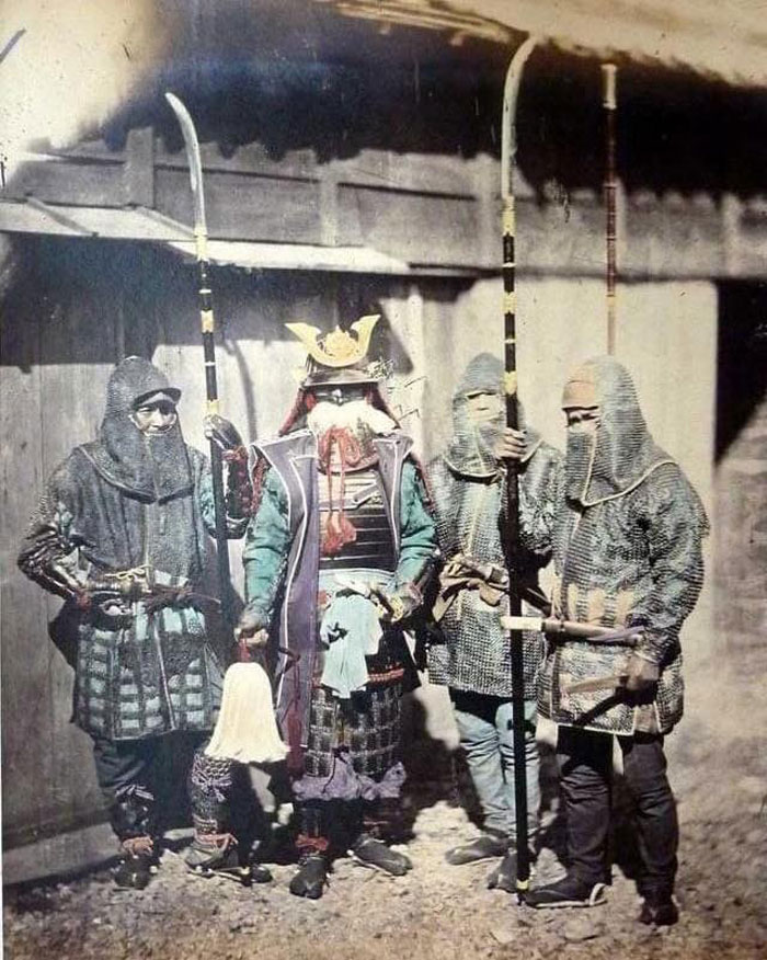 un samouraï et ses serviteurs portant une armure de mailles et armés de naginata, 1870