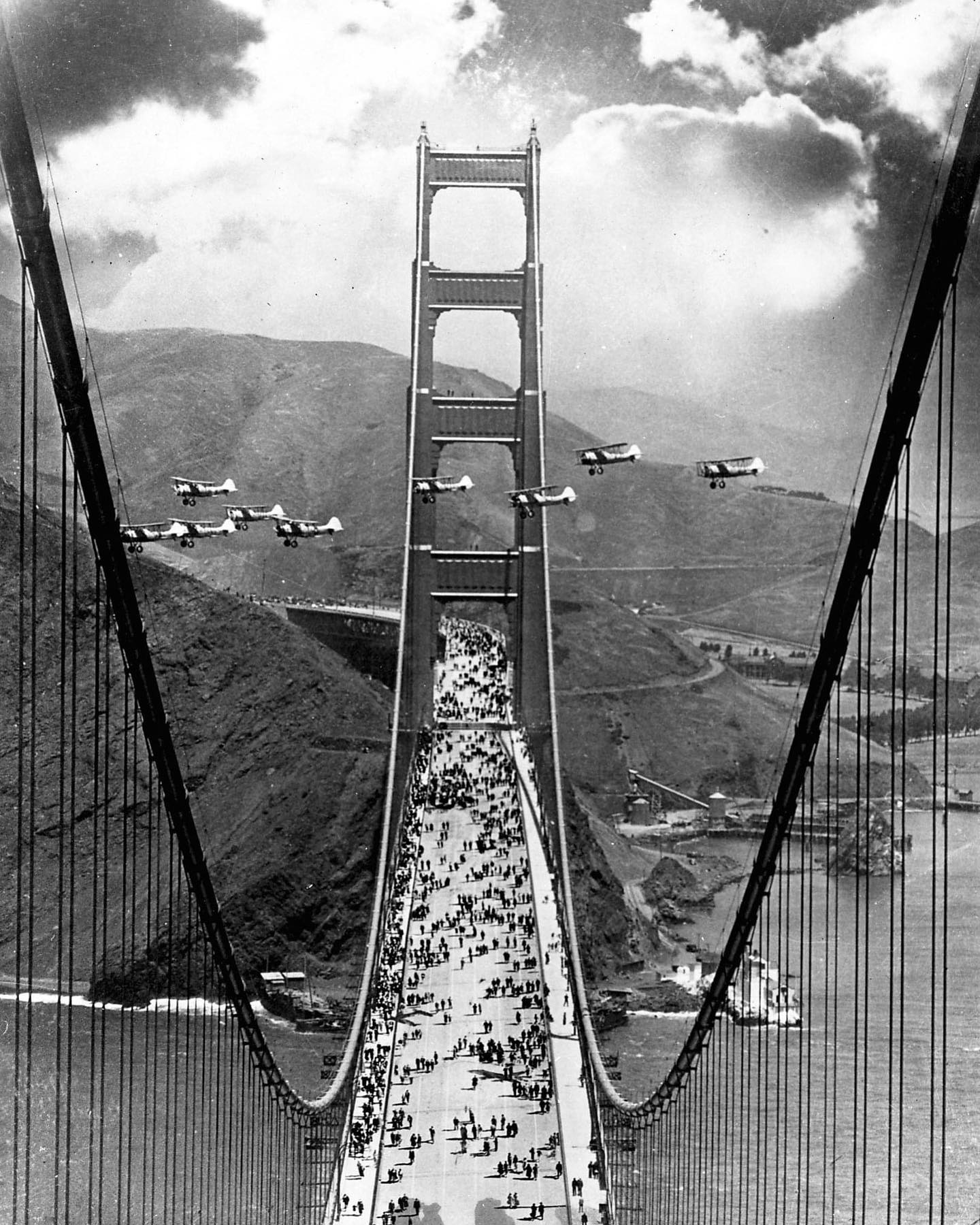 Des avions volent entre les tours et des piétons traversent lors de la célébration de l’ouverture du Golden Gate Bridge en mai 1937.