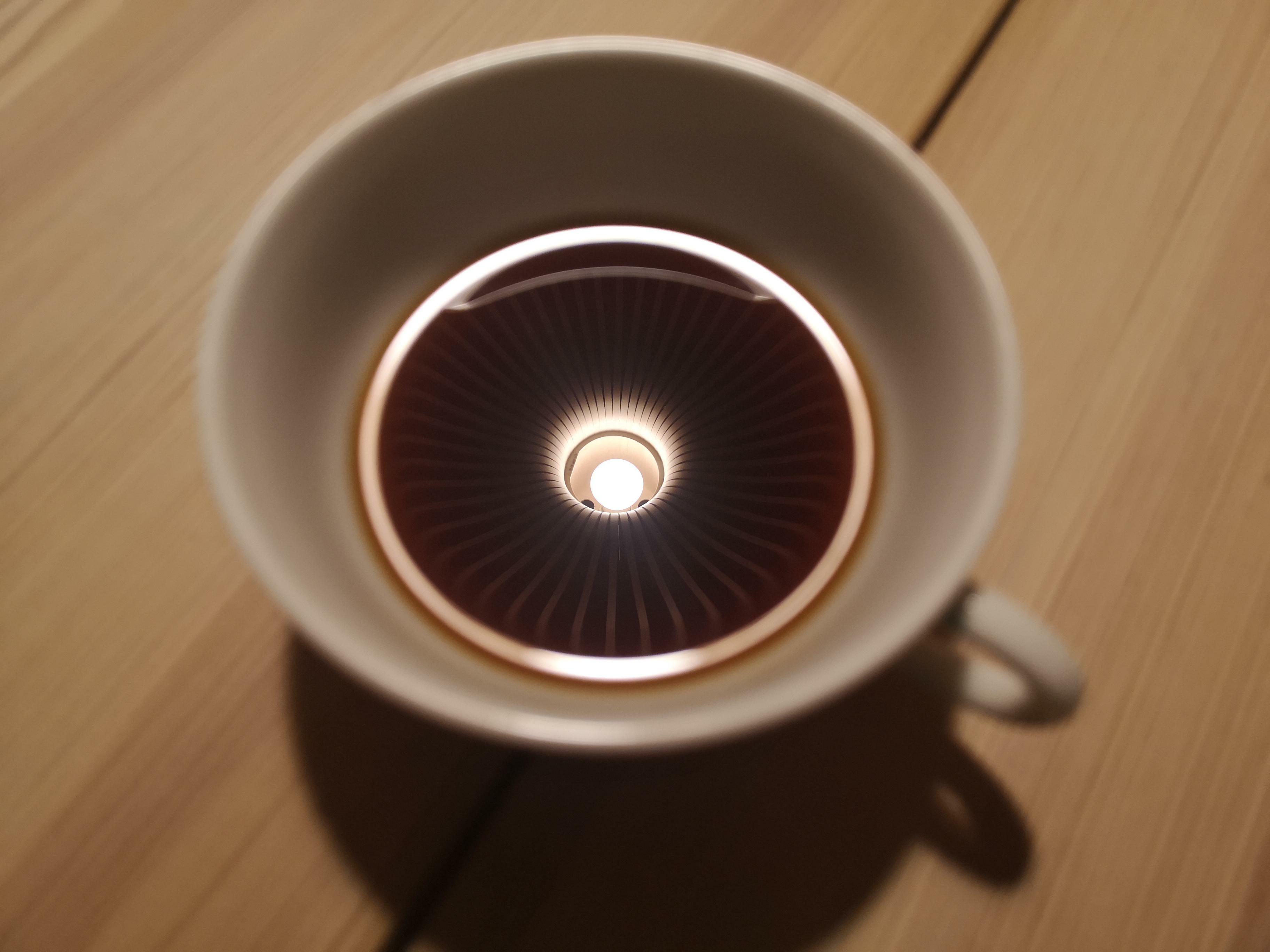 itap de ma tasse à café avec le reflet d'une lampe