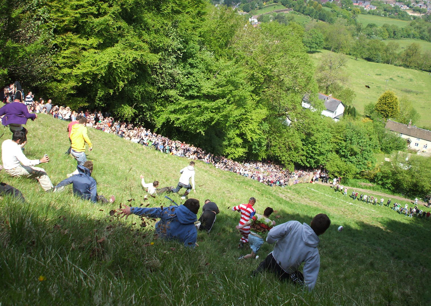 dans le gloucestershire, en angleterre, les gens se rassemblent pour faire rouler le fromage en bas d’une colline