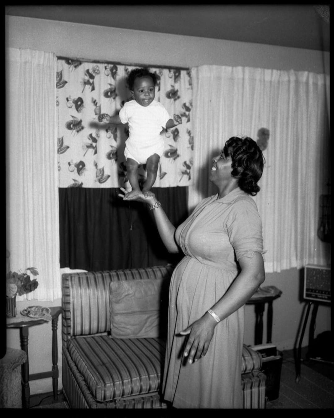 une petite fille en équilibre sur la main de sa mère à pittsburgh . prise au milieu des années 1900