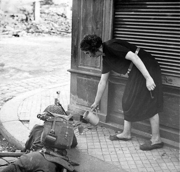 une femme française verse du cidre pour un artilleur britannique à lisieux, france, 22 août 1944