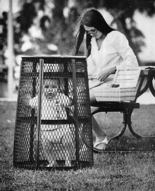 une mère utilise une poubelle pour contenir son bébé pendant qu’elle fait du crochet dans le parc, 1969