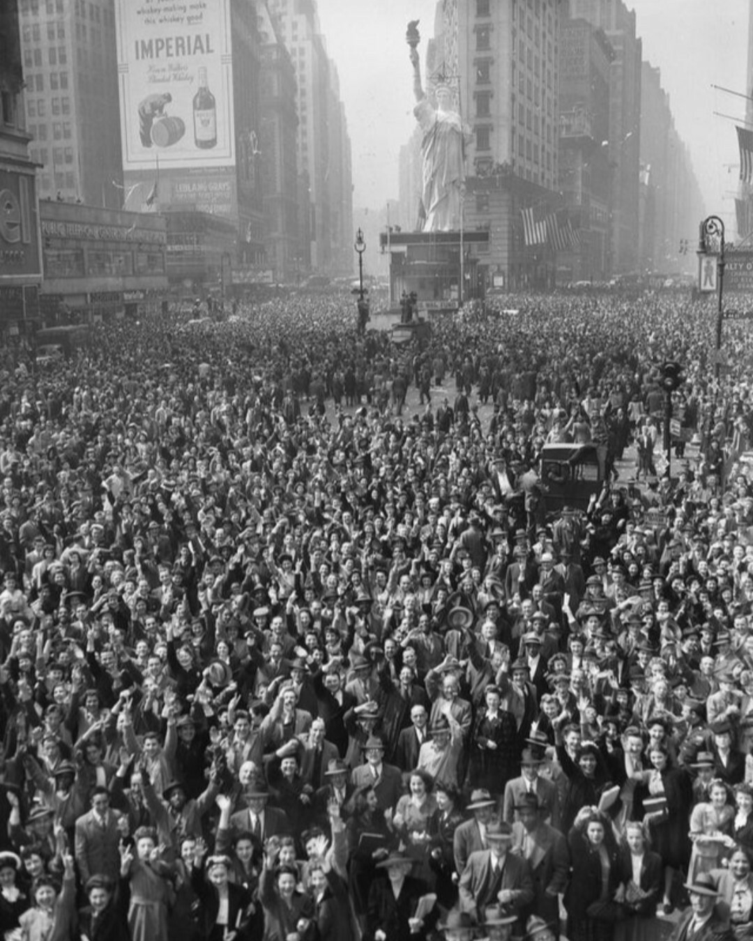 une foule à time square, new york city, célébrant la capitulation de l’allemagne pendant la deuxième guerre mondiale. cette photo a été prise le 7 mai 1945.