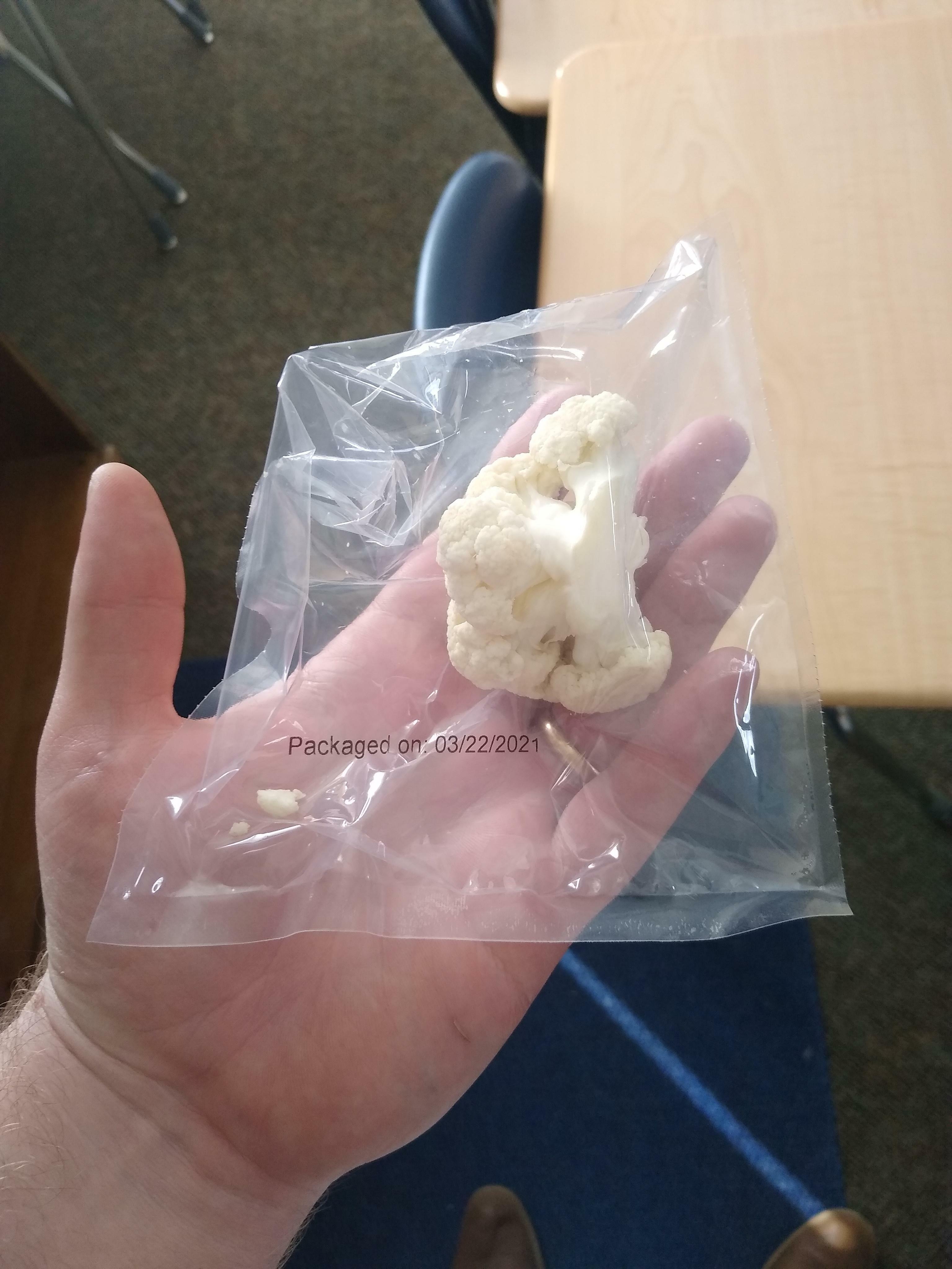 un seul chou-fleur dans un emballage plastique à usage unique provenant d'un repas scolaire.