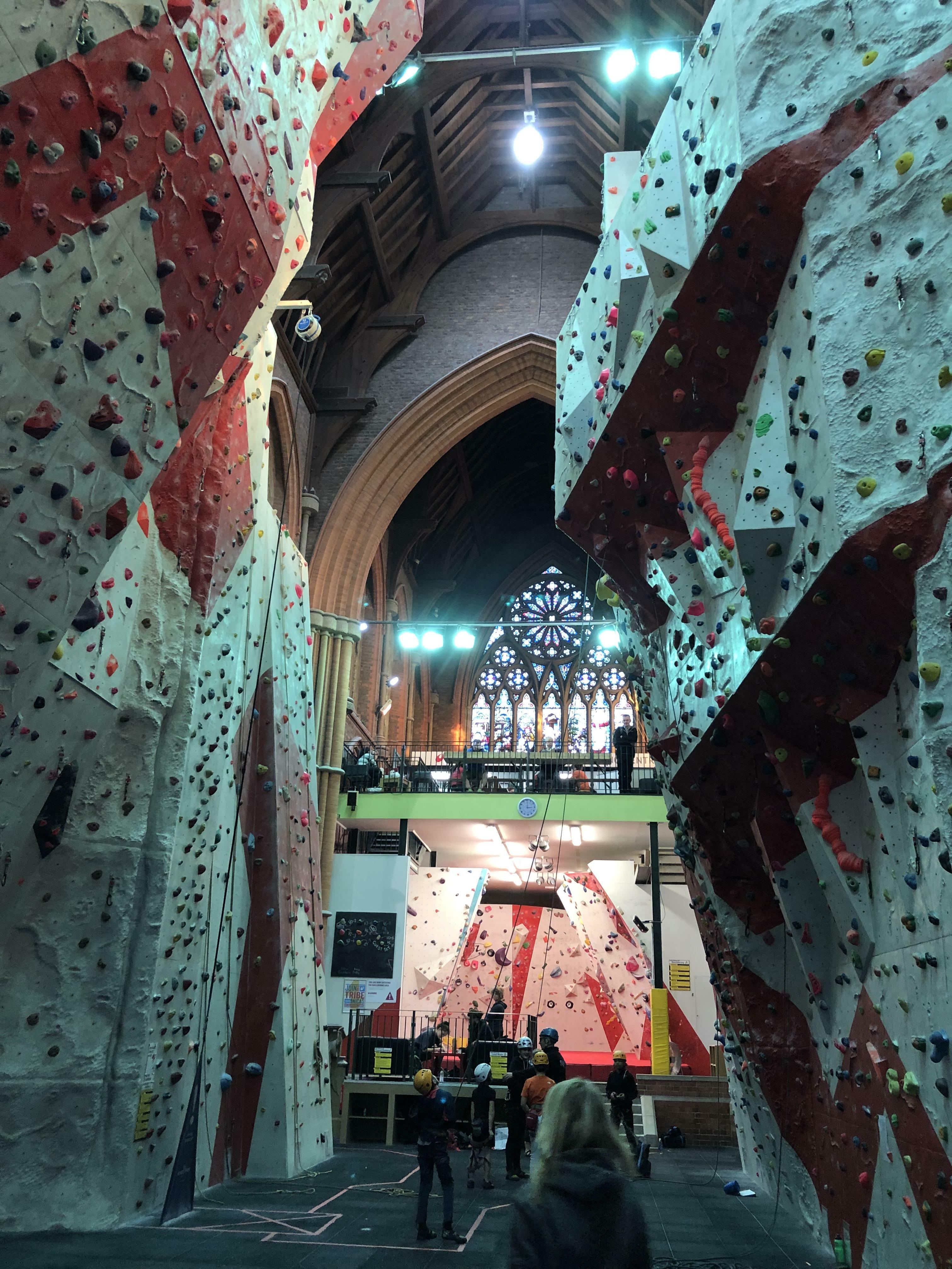 Une vieille église magnifique a été transformée en un centre d'escalade génial, en conservant des éléments originaux comme des vitraux et un autel (manchester climbing center, uk).