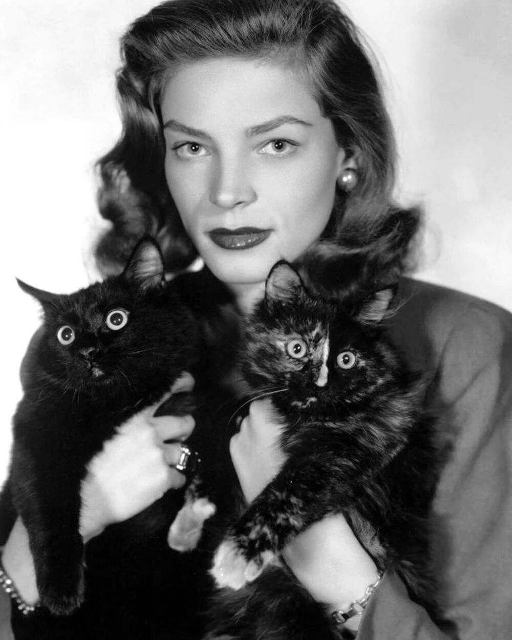 L’actrice hollywoodienne de l’âge d’or, Lauren Bacall, a posé pour ce portrait avec deux chats qui ressemblaient plutôt à des petits hiboux. 1940