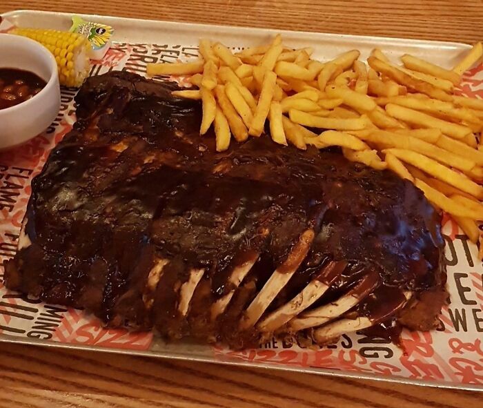 énormes côtes avec frites, haricots bbq, salade de chou et épis de maïs