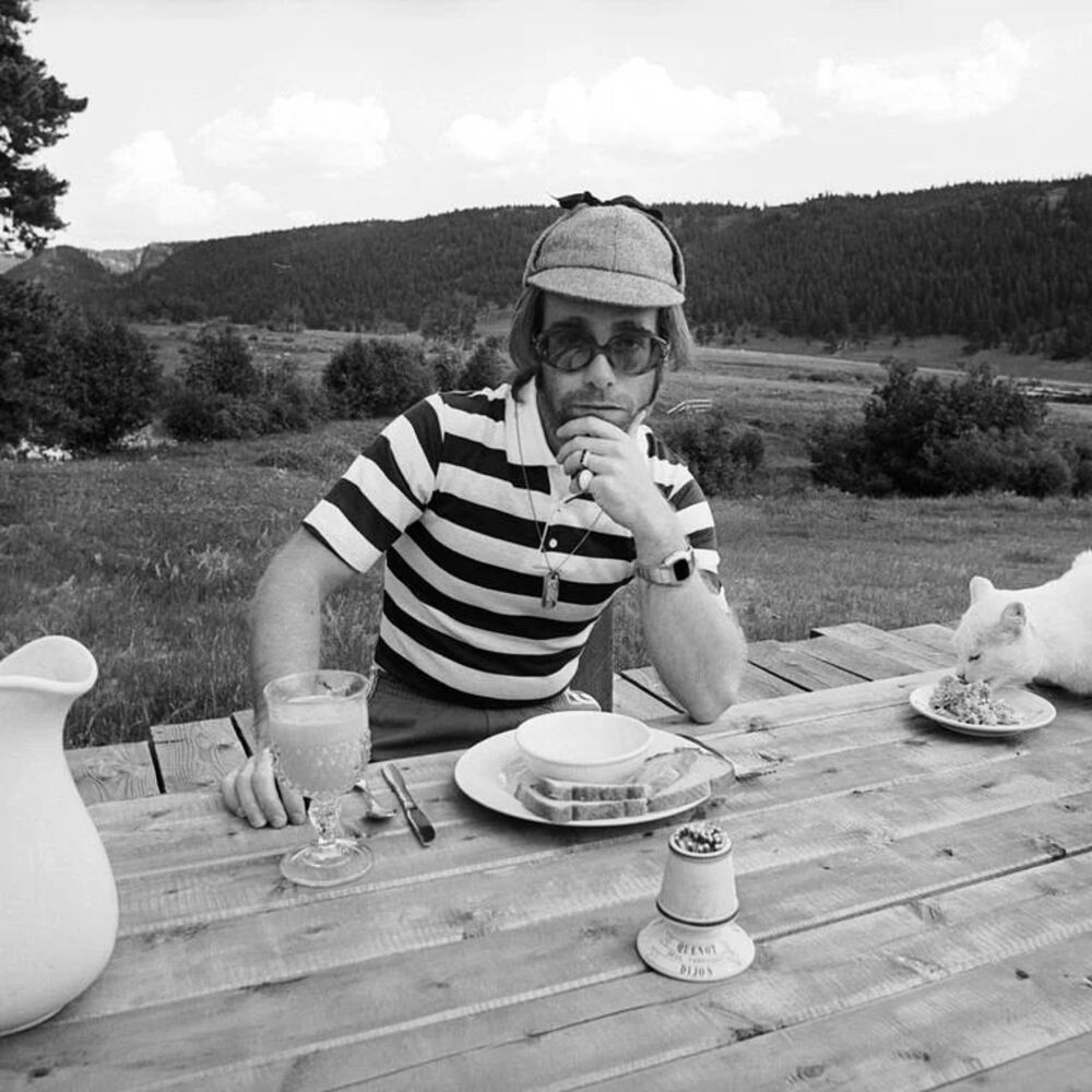 Pendant que la star britannique elton john posait pour le célèbre photographe terry o’neill, un chat a volé la vedette avec son goûter. colorado, états-unis. 1974