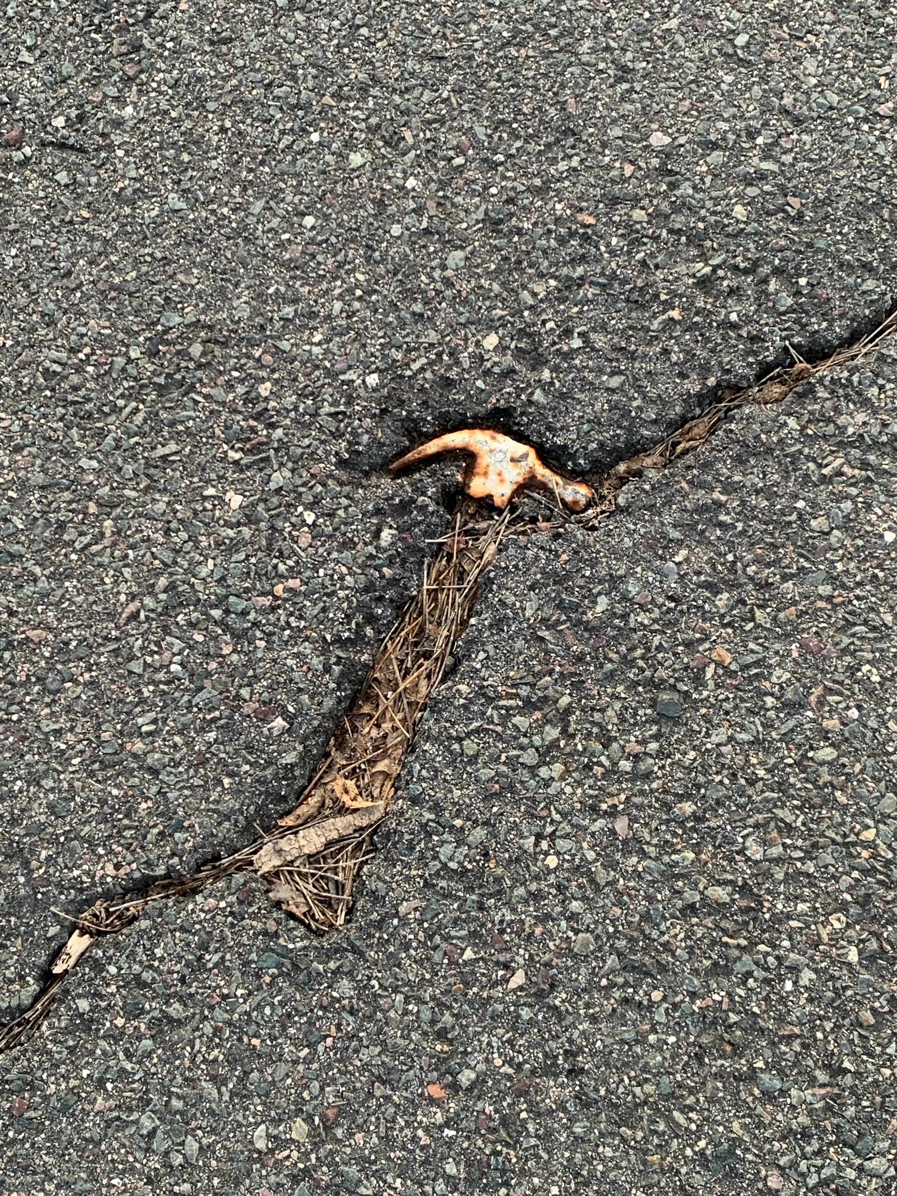 les restes de ce marteau enfoncés dans l'asphalte