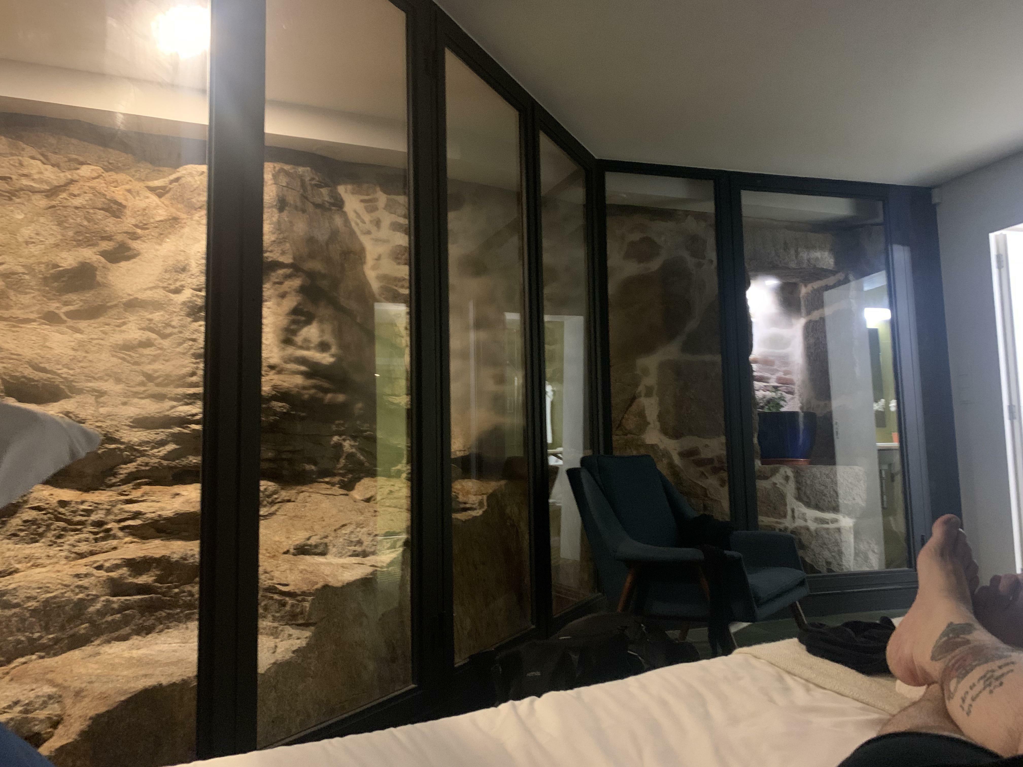 mon appartement pour la nuit à porto, au portugal, possède un mur et un escalier du 12e siècle préservés, encastrés dans la chambre à coucher.