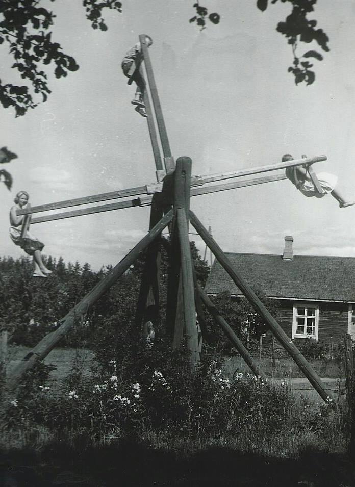Une famille s’amuse sur une balançoire artisanale unique pour quatre personnes en Finlande, 1954.