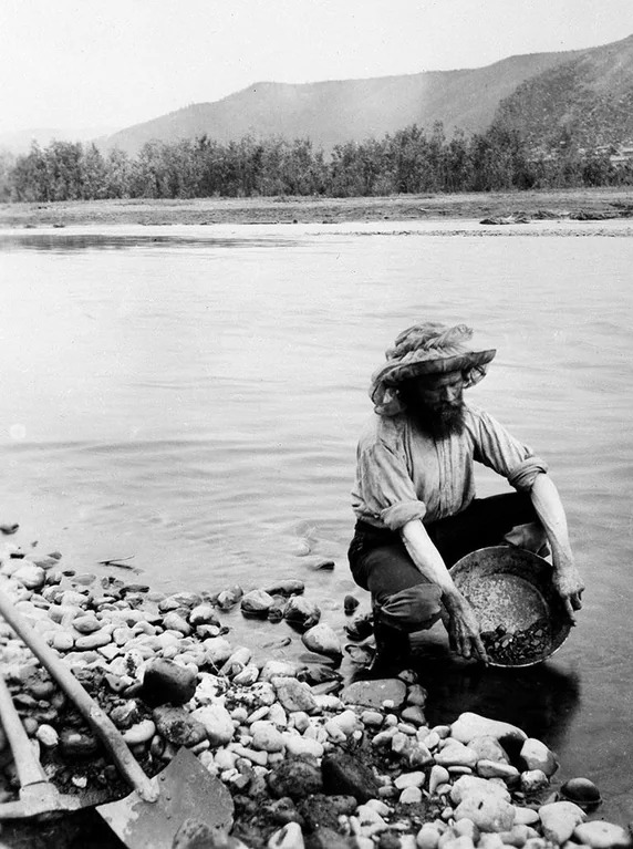 un prospecteur cherche de l’or dans la rivière yukon pendant la ruée vers l’or du klondike en 1896. dawson city, territoire du yukon, canada