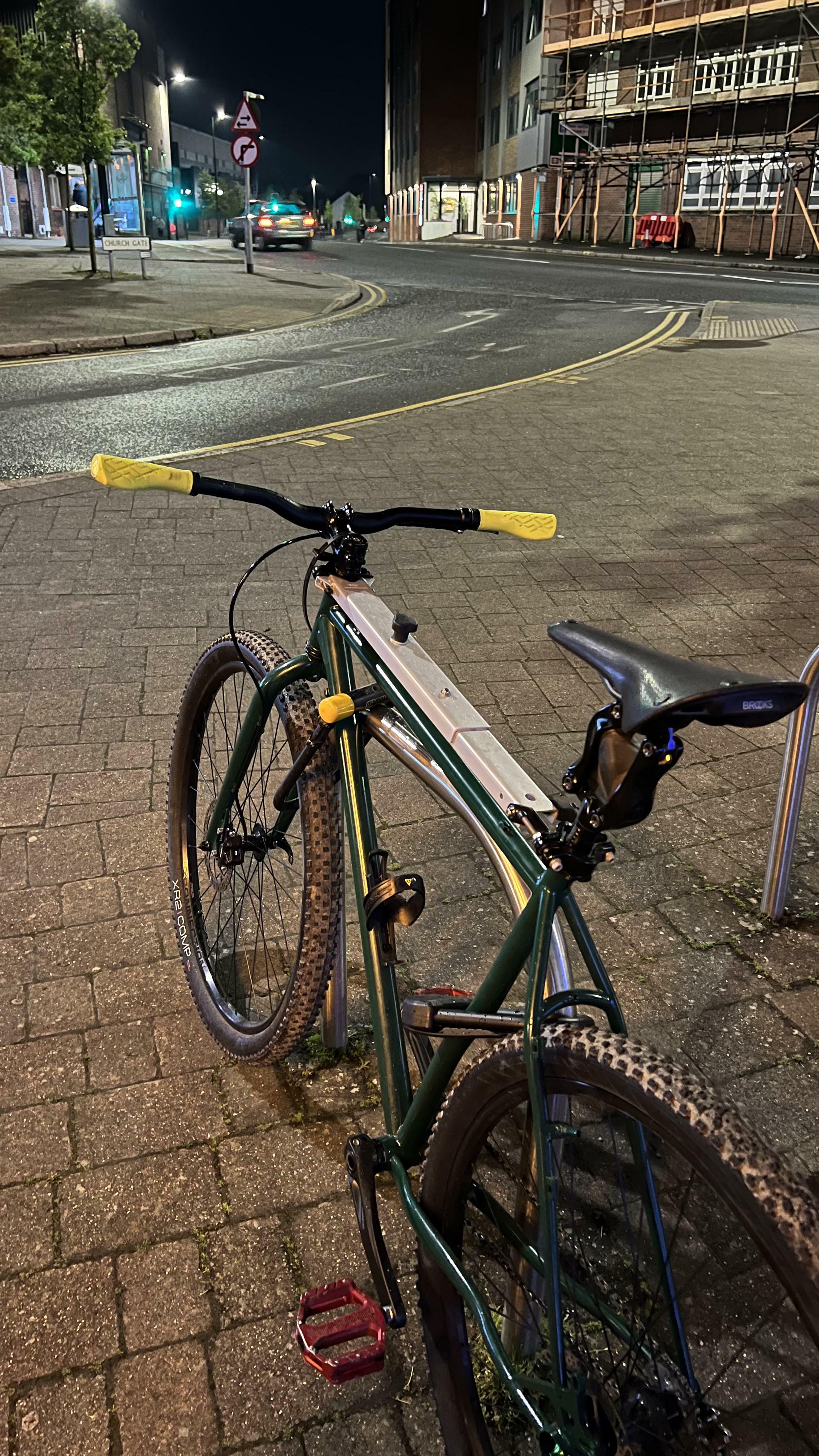 grande barre métallique en haut d'un cadre de vélo, apparemment pliable, avec un bouton