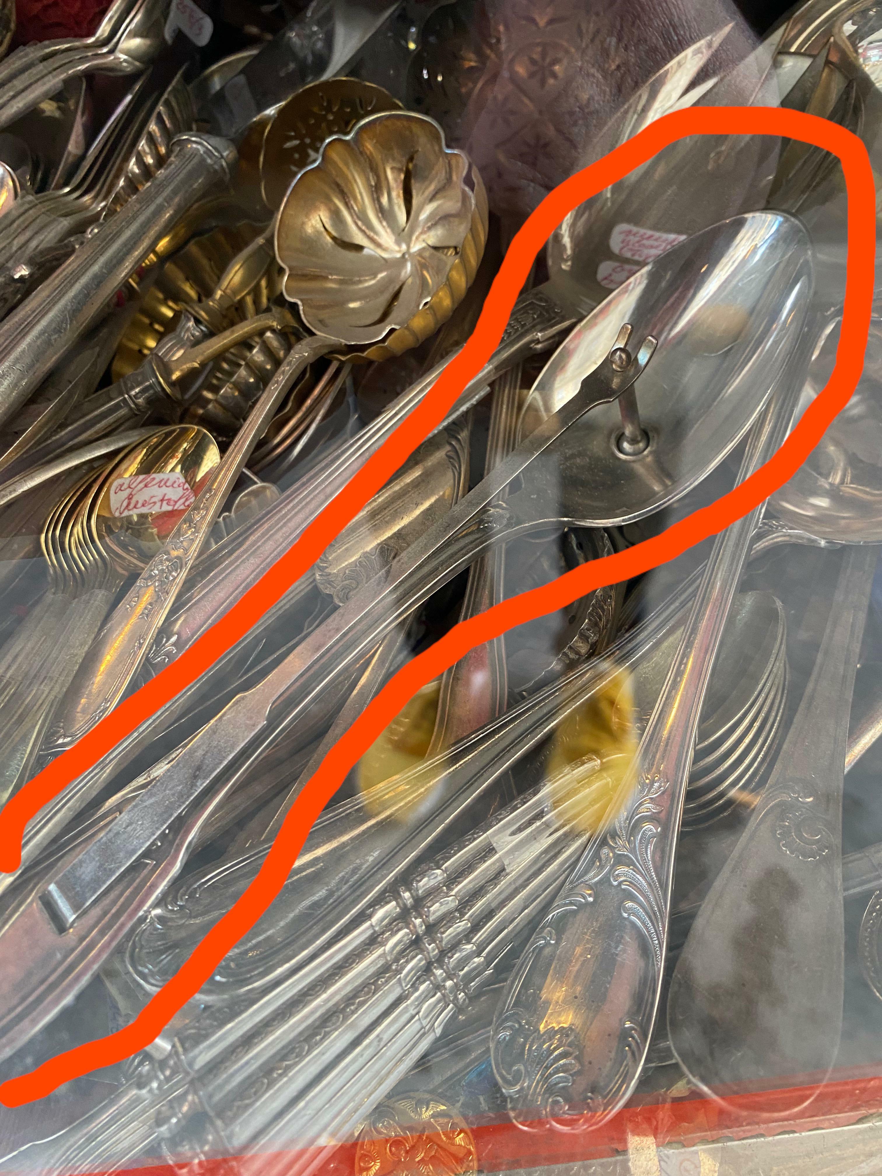 Qu'est-ce que c'est que cette cuillère avec une attache en forme de langue ? vue dans un magasin d'antiquités à Lyon, en France.