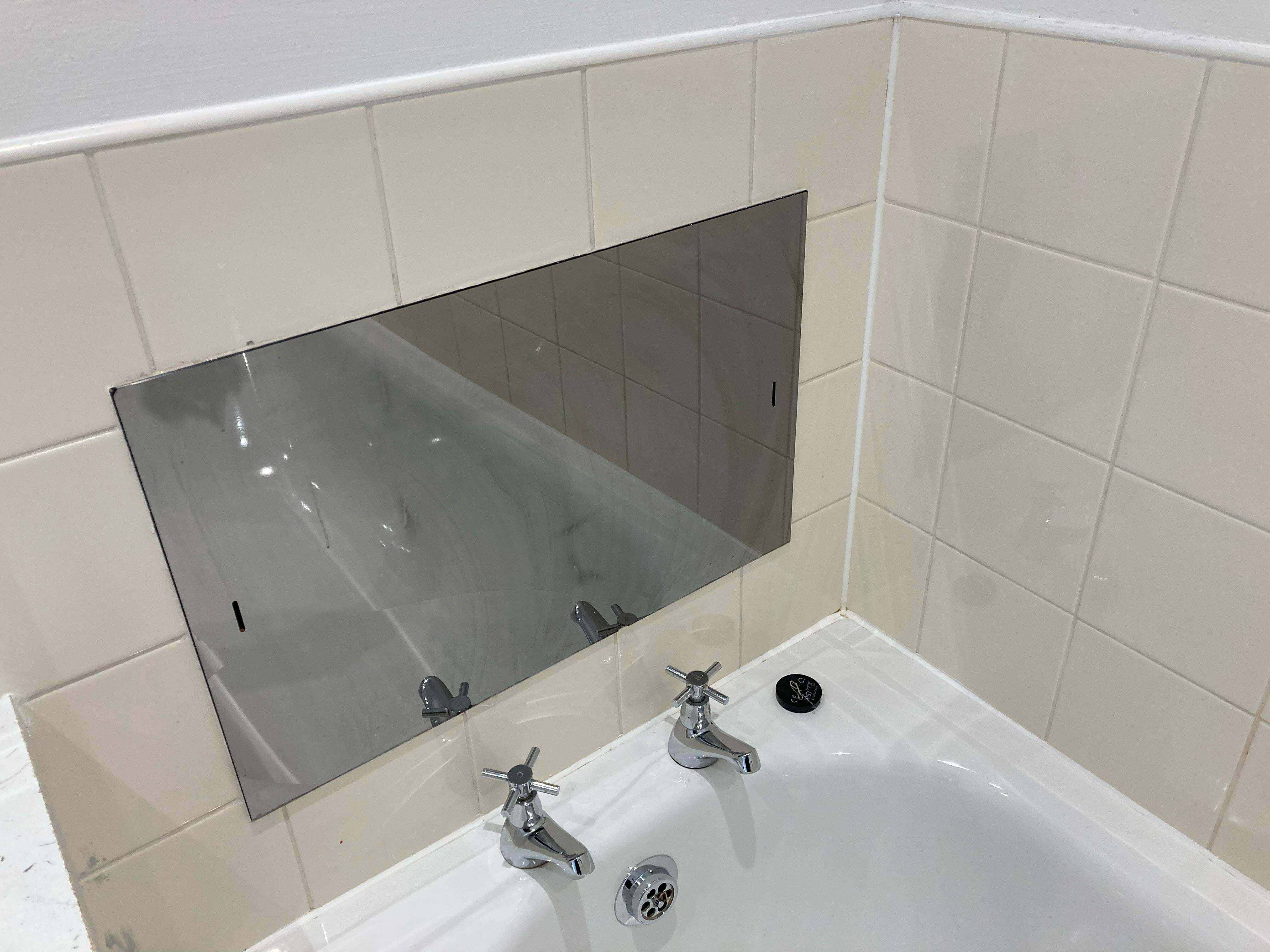 Qu'est-ce que cet étrange panneau en miroir au-dessus de la baignoire dans mon nouvel appartement au Royaume-Uni ?