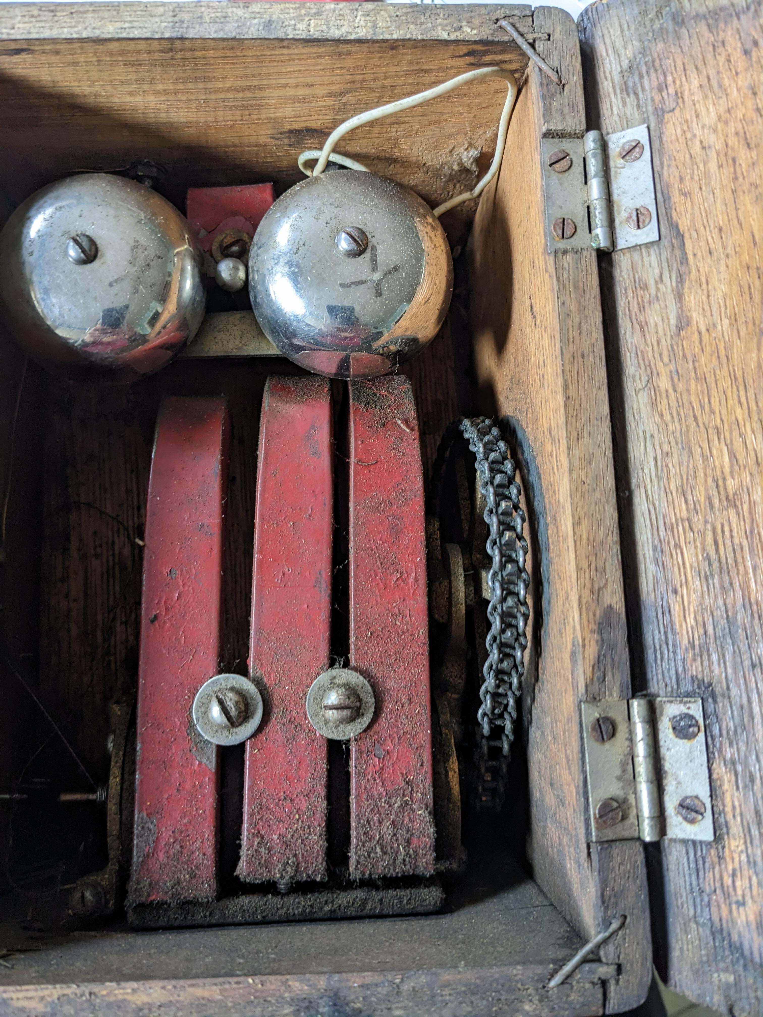 Quel est ce mécanisme ? Il se trouve dans une boîte en bois et comporte une manivelle qui fait tourner une chaîne à l'intérieur, ce qui pourrait générer de l'électricité ?