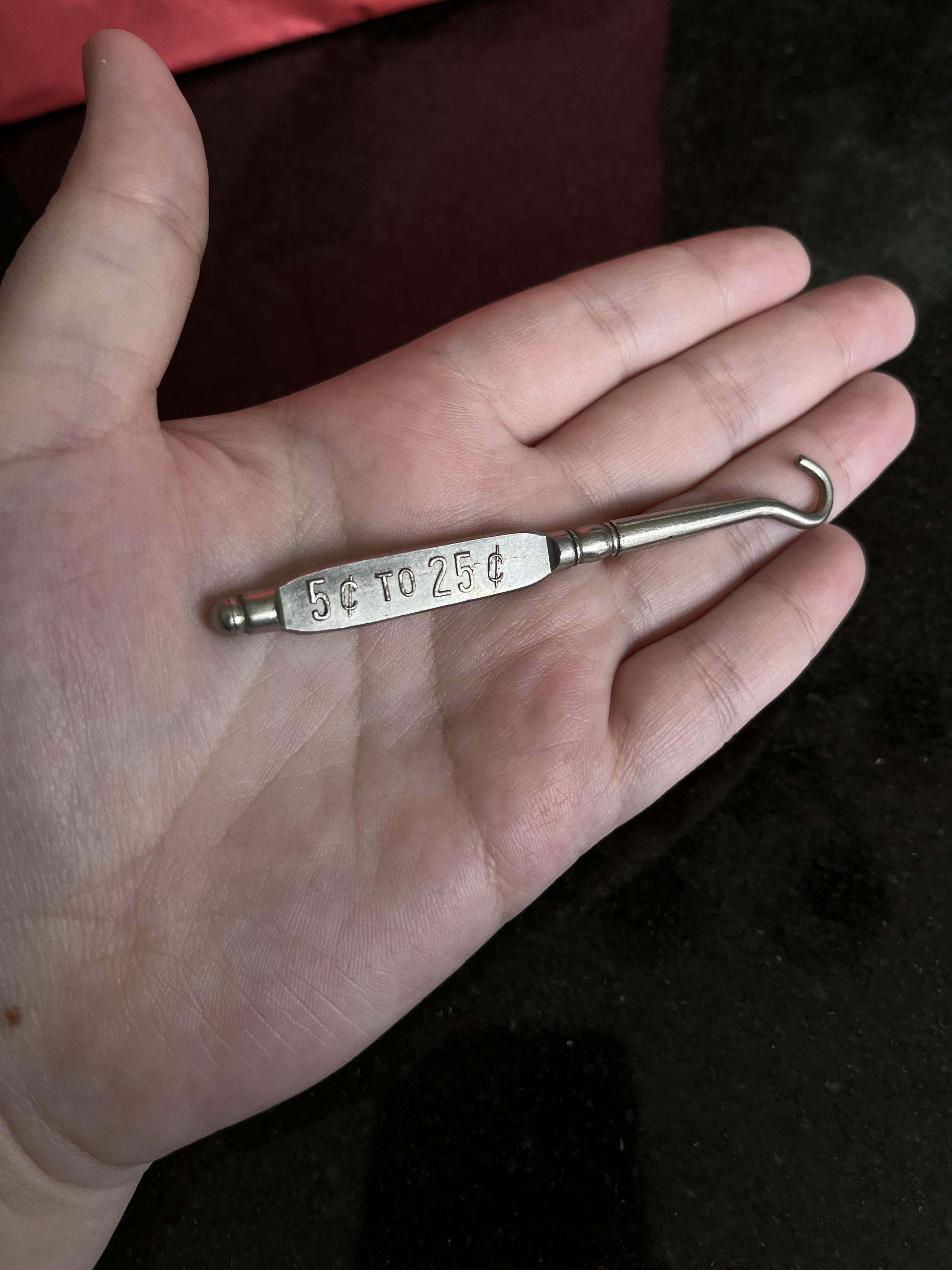 petit outil en métal avec un crochet au bout. trouvé avec de vieilles clés et des bijoux
