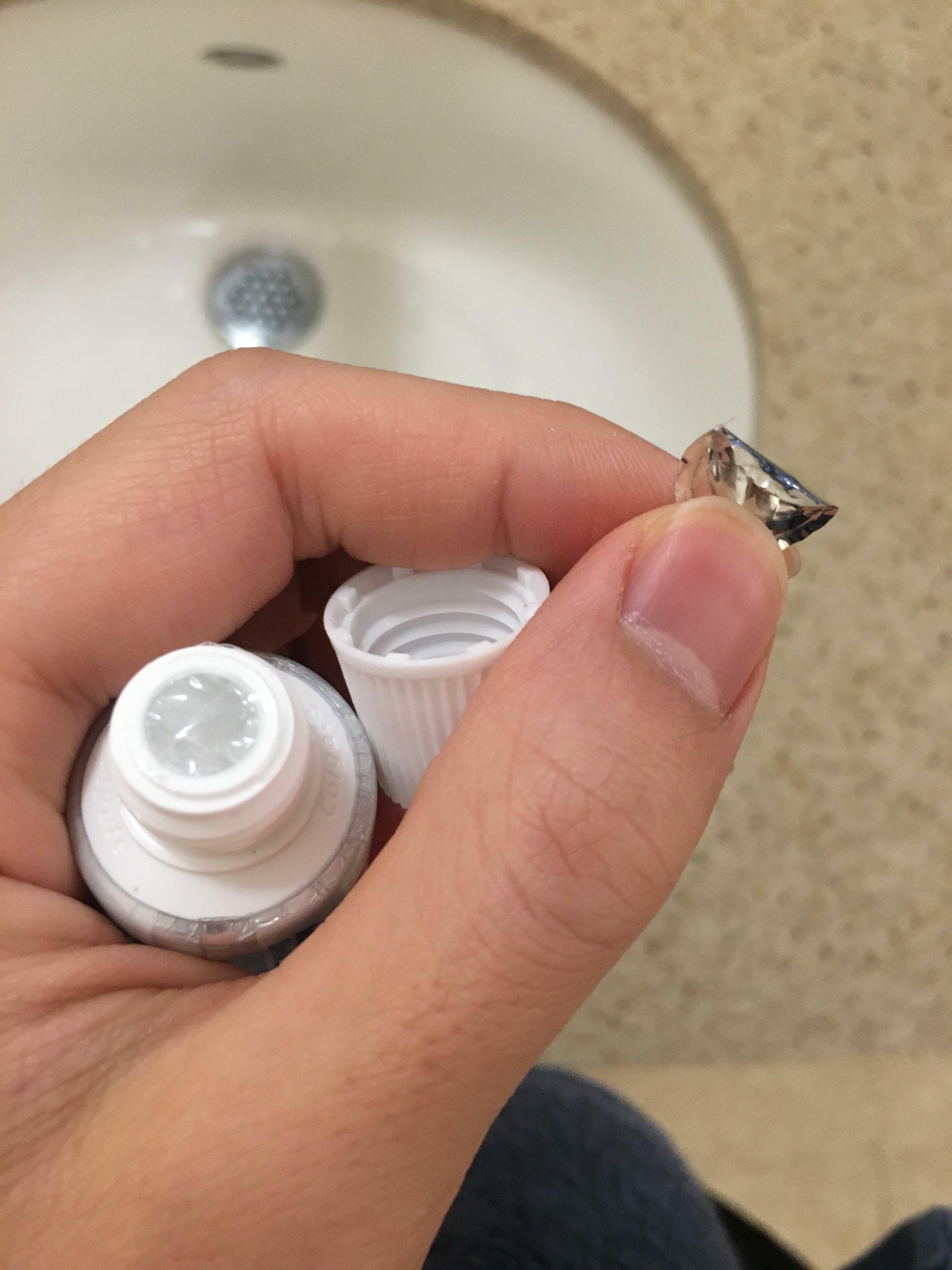 Après avoir enlevé la pellicule métallique de ce dentifrice, il restait une pellicule de plastique transparent sur la tête sans qu'il y ait de languette pour l'enlever.