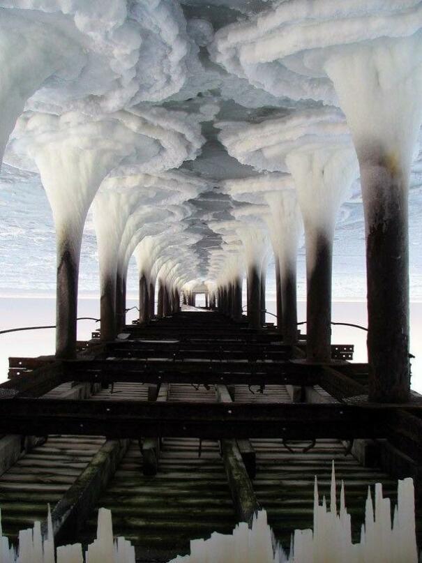 Si tu retournes la photo de “l’eau gelée sous une jetée”, elle se transforme en paysage urbain industriel.