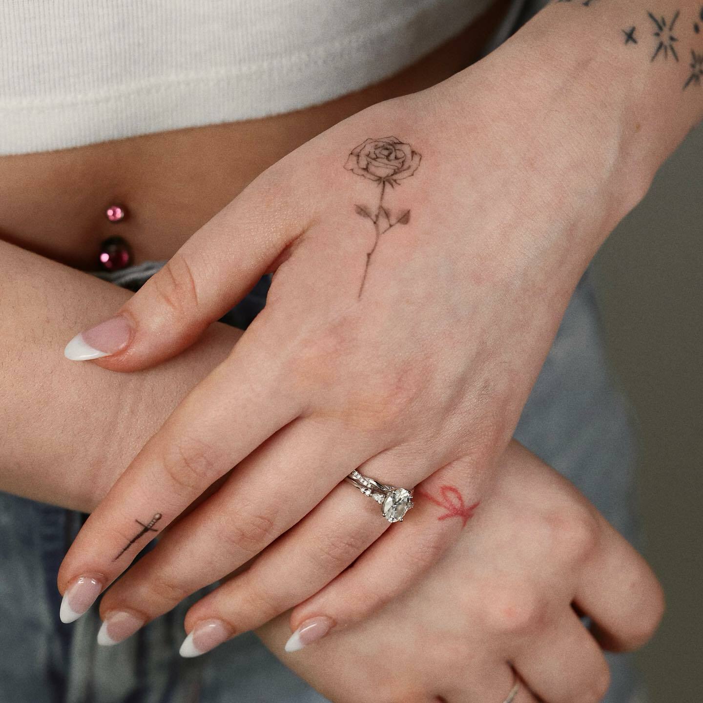 tatouages de rose et de poignard sur la main