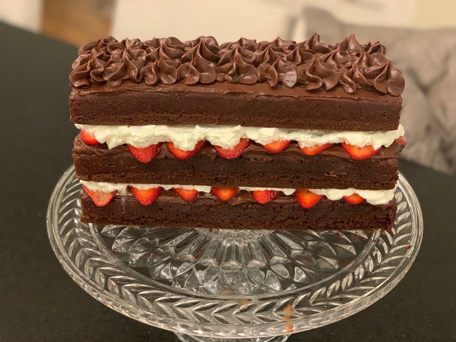 un gâteau au chocolat fait maison avec des fraises et de la crème