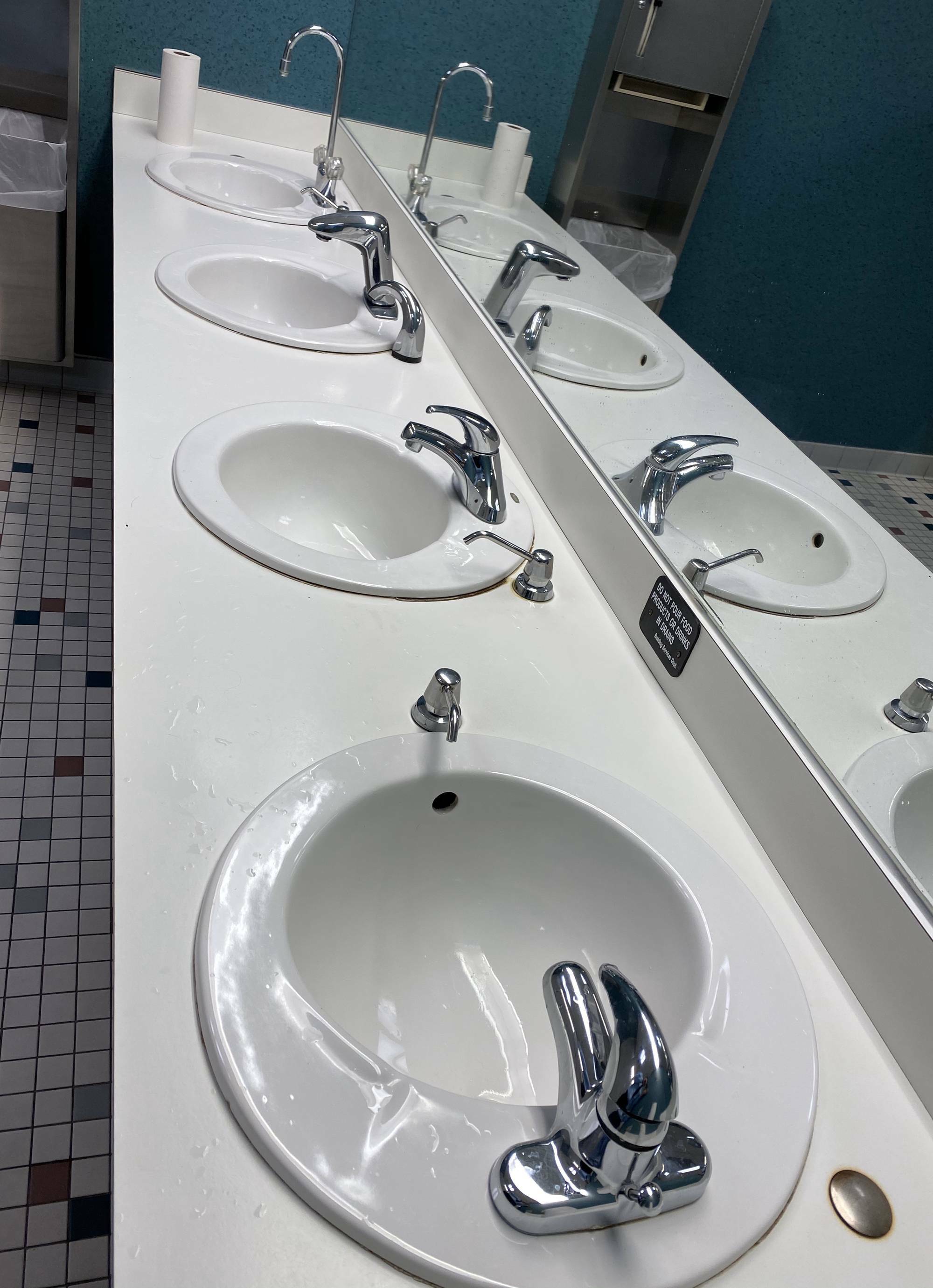 Chaque lavabo de cette salle de bain a un robinet différent.