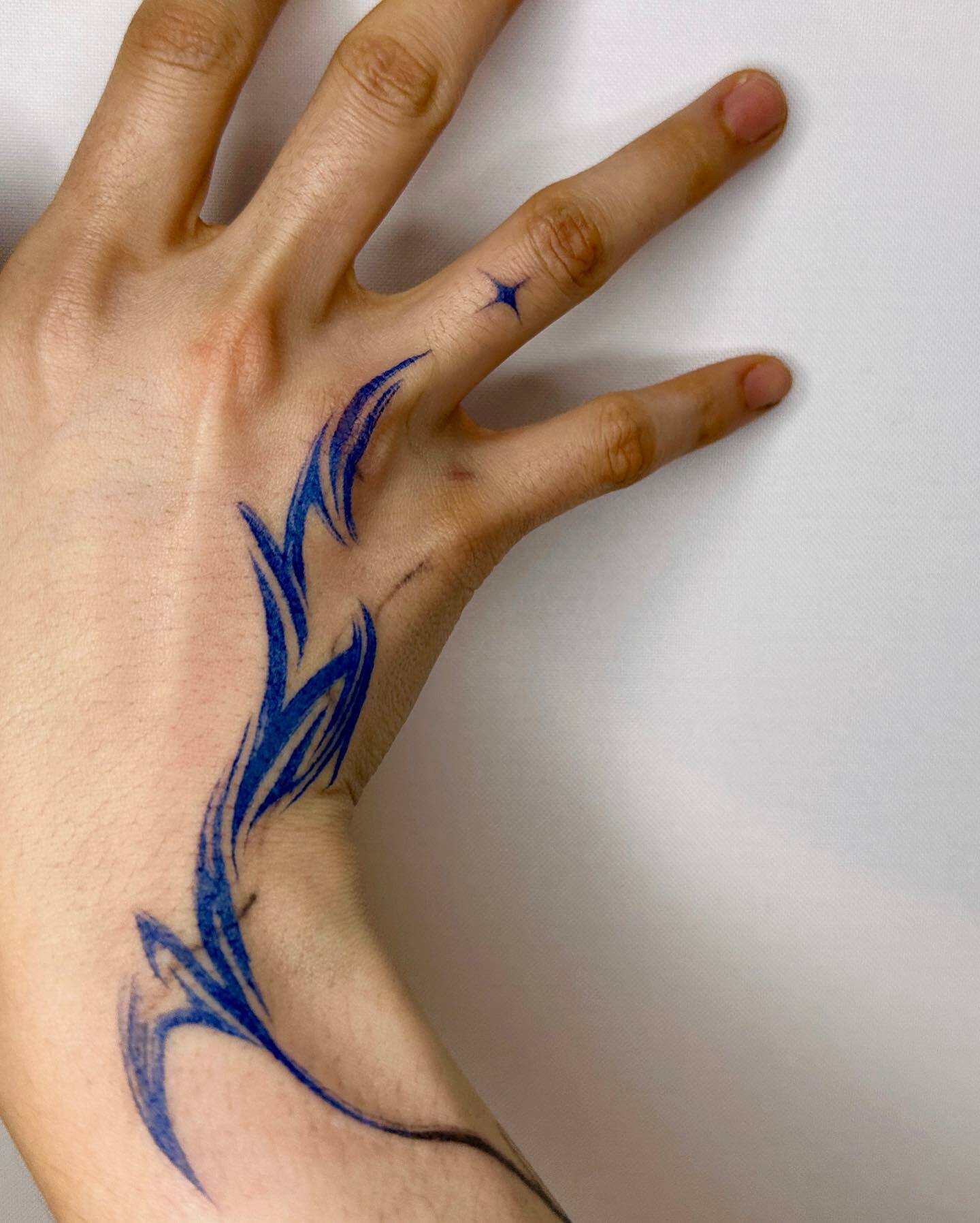 tatouage abstrait bleu sur la main