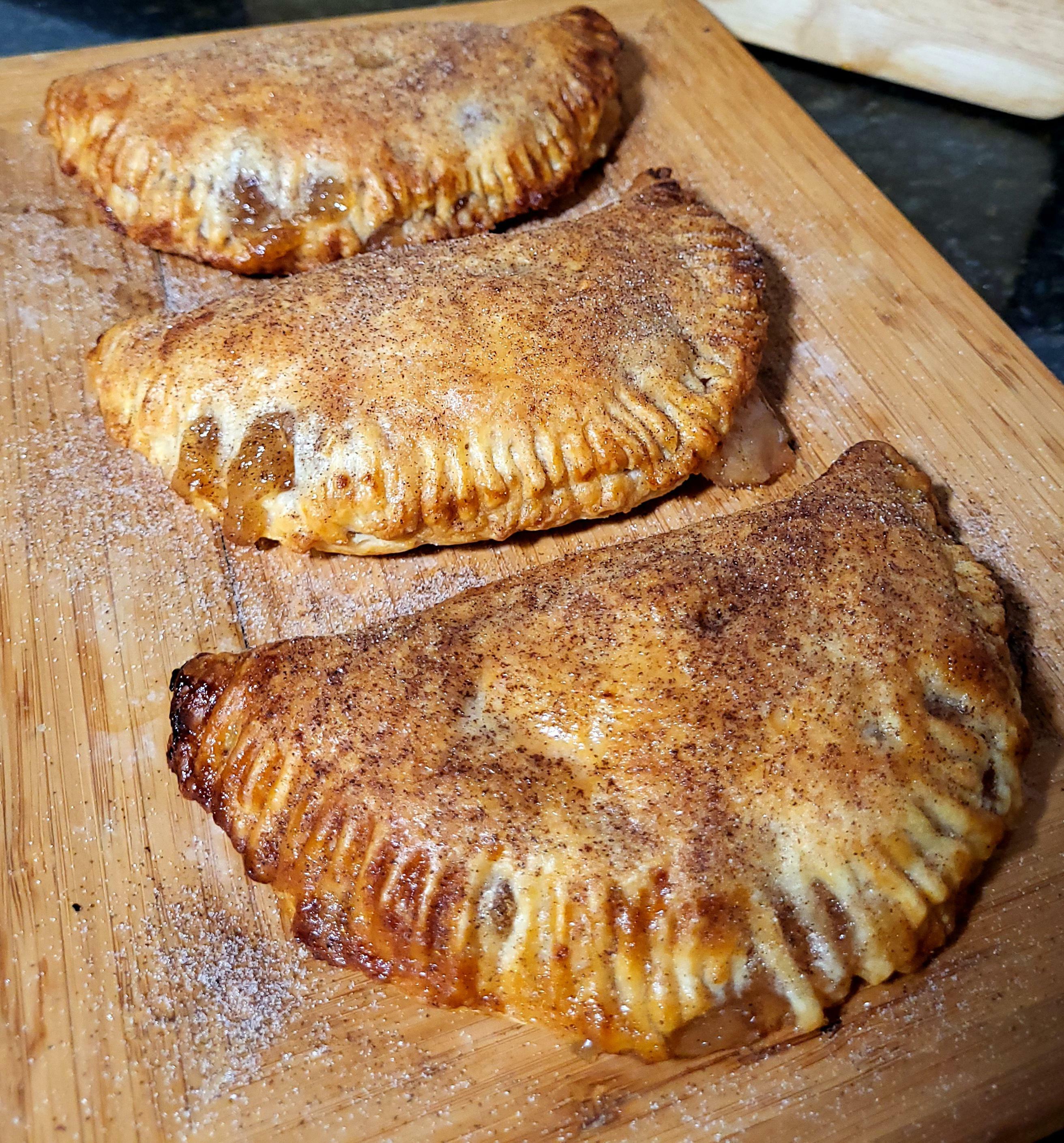 mes chaussons aux pommes maison badigeonnés de beurre fondu et garnis de sucre à la cannelle.