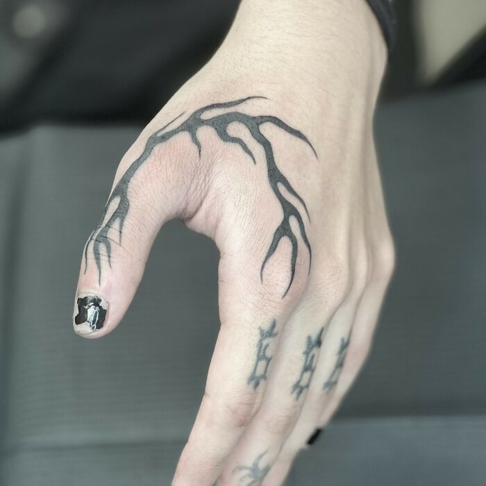 C’est un petit tatouage de flamme noire sur la main.