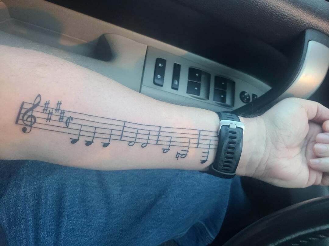 Tatouage du bras avec des notes de musique