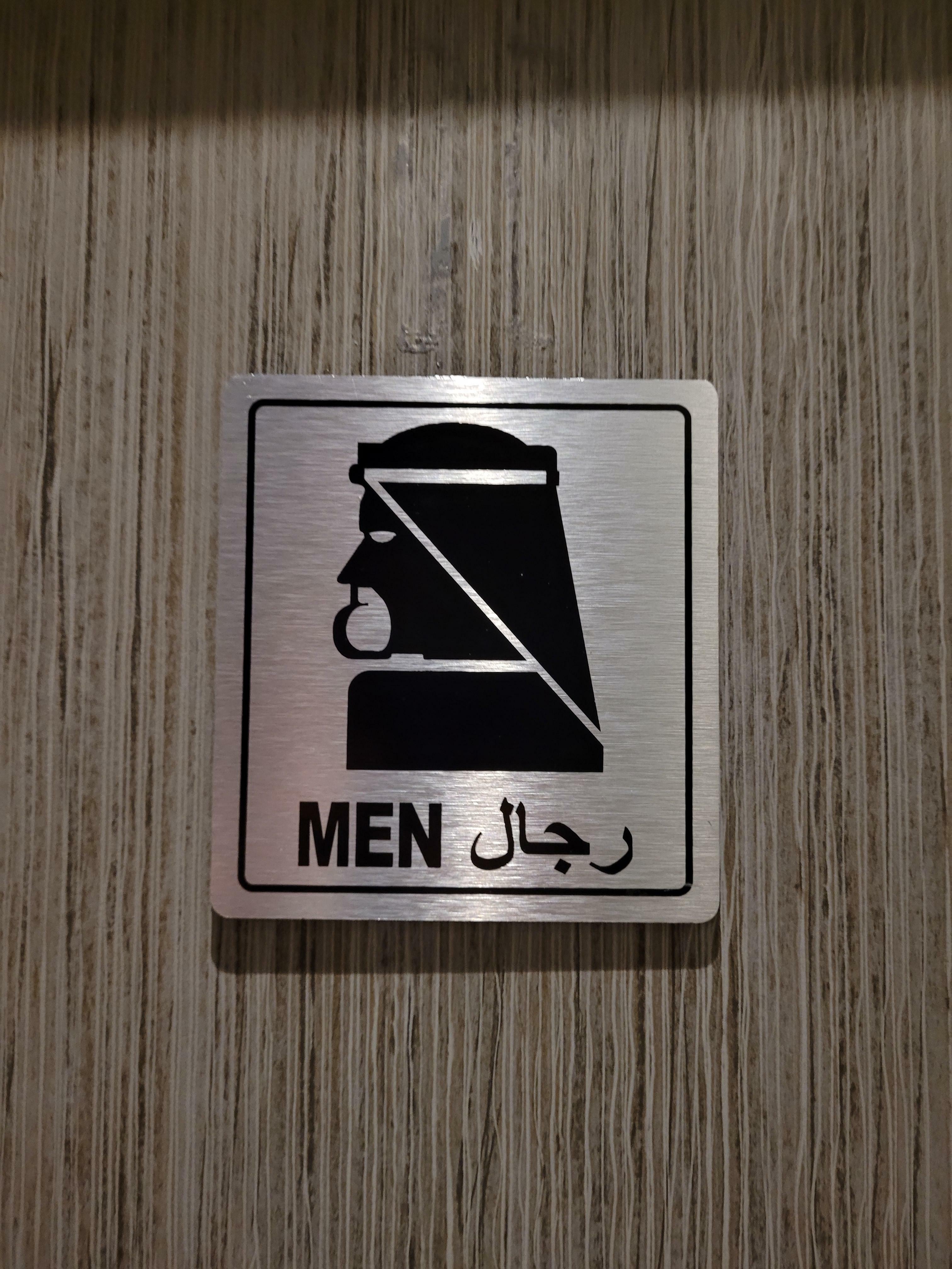 Ce panneau des toilettes dans un salon de l'aéroport d'Abu Dhabi ressemble à Batman arabe.