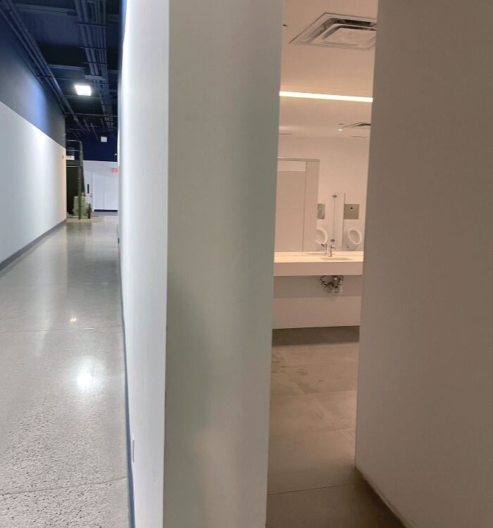 L’emplacement du miroir et des urinoirs dans notre immeuble de bureaux. Voici le couloir principal