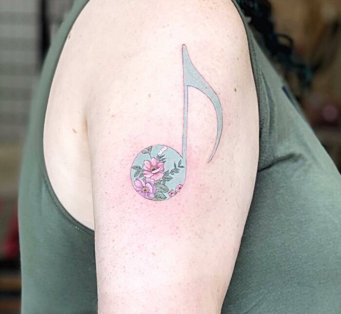 Tatouage de notes bleues pastel avec des fleurs