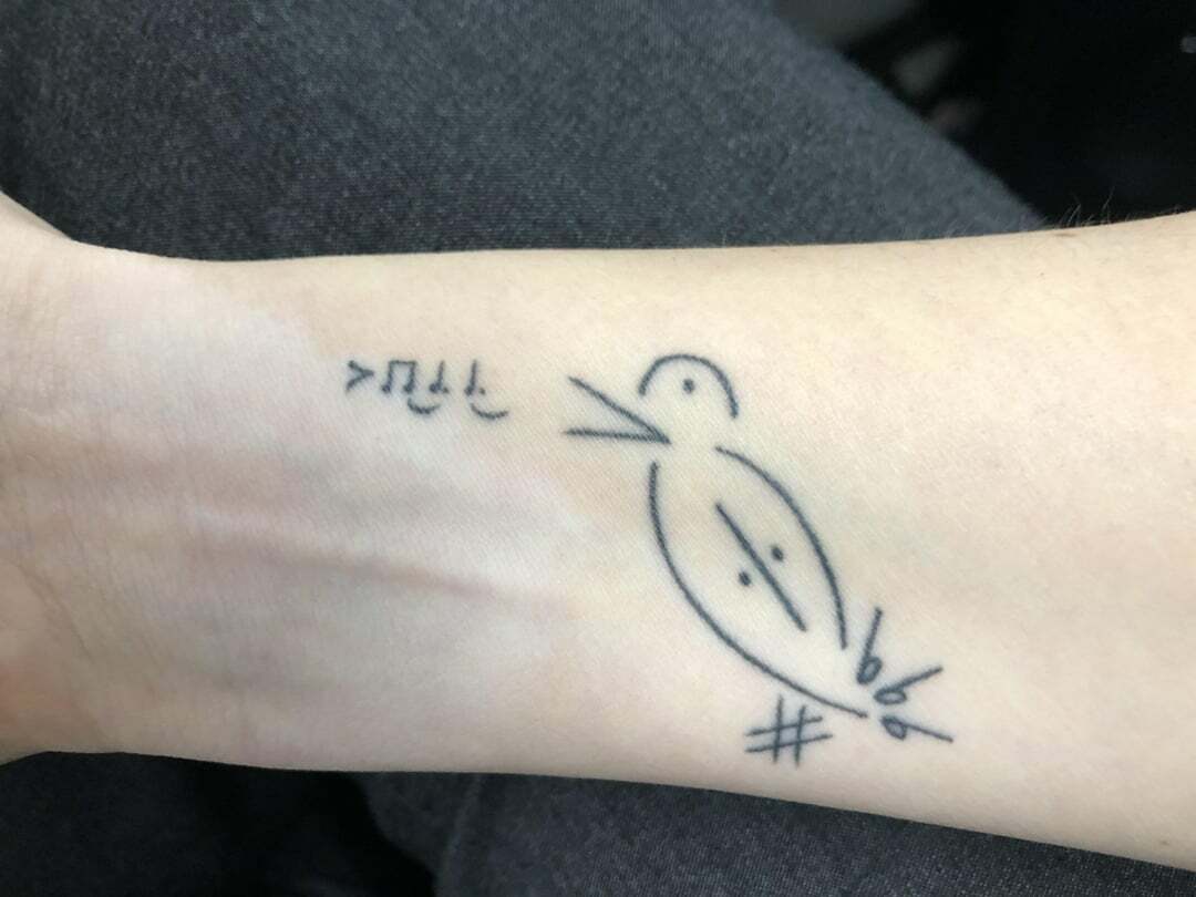 Tatouage d’oiseau avec symboles musicaux minimaux