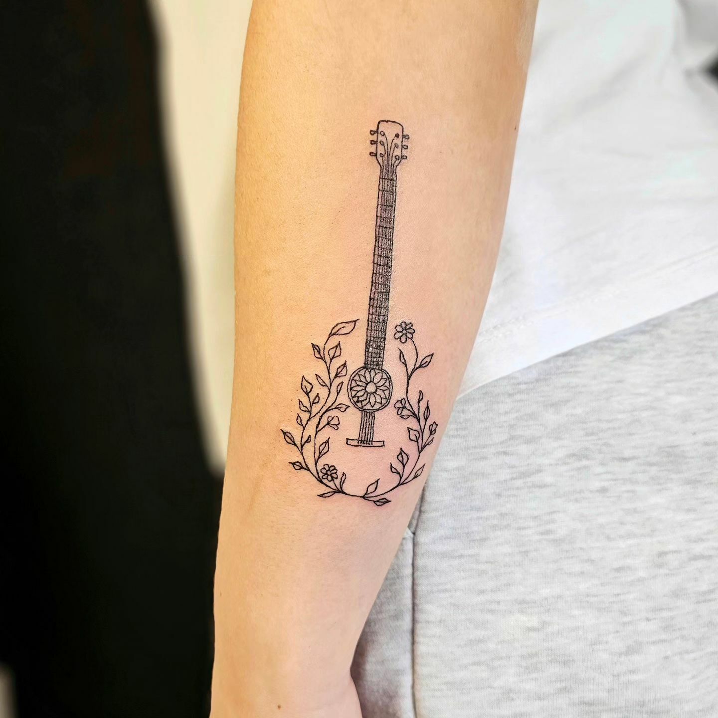 Tatouage de bras en forme de guitare florale